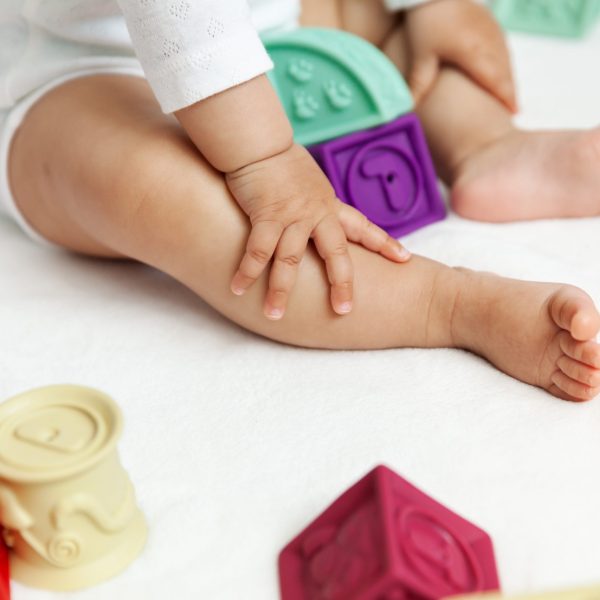 Happy baby playing with colorful blocks on the floor, natural light, selective focus, maternity and childhood concept - Image